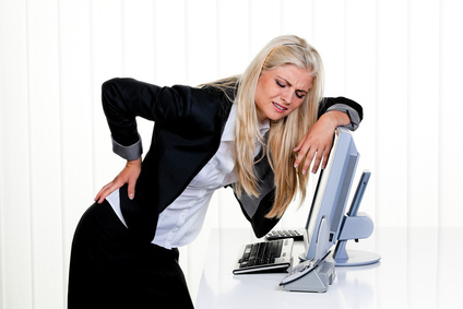Frau mit Schmerzen im Rücken im Büro